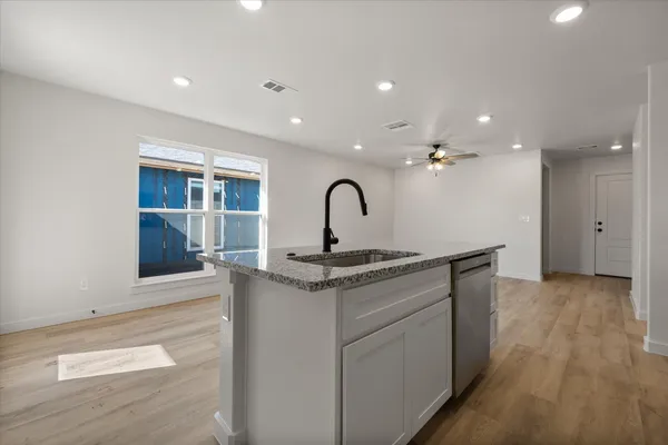 a kitchen with a granite countertop sink a stove and refrigerator