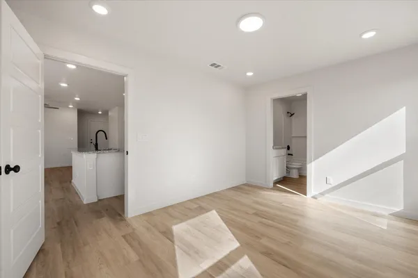 a view of a hallway with wooden floor and staircase