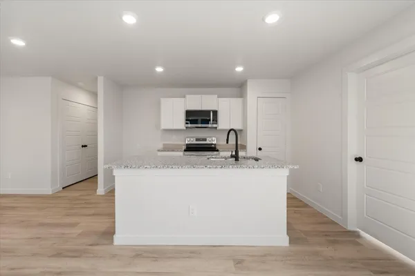a kitchen with kitchen island a sink stainless steel appliances and cabinets