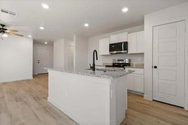 a kitchen with stainless steel appliances granite countertop a sink stove and refrigerator