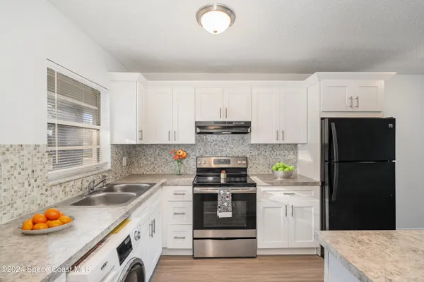a kitchen with stainless steel appliances granite countertop a stove a refrigerator and a sink
