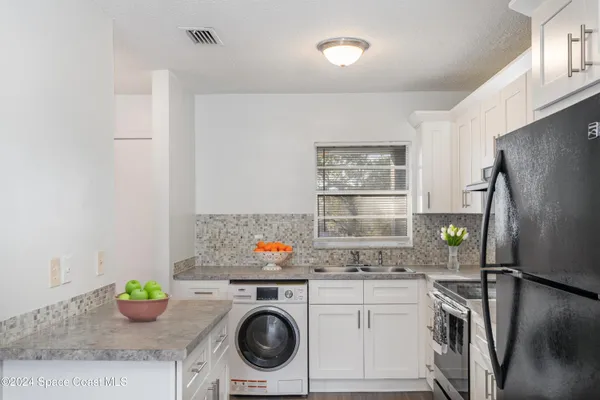 a kitchen with a refrigerator and a stove top oven
