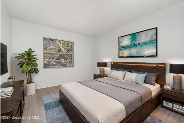 a bedroom with bed and paintings on the wall