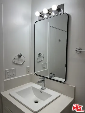 a bathroom with a sink vanity and a mirror