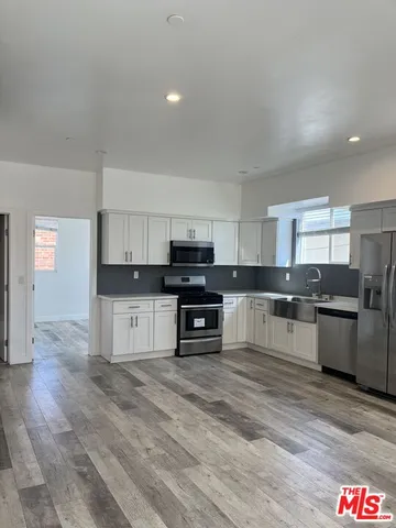 a kitchen with granite countertop a stove top oven and cabinets