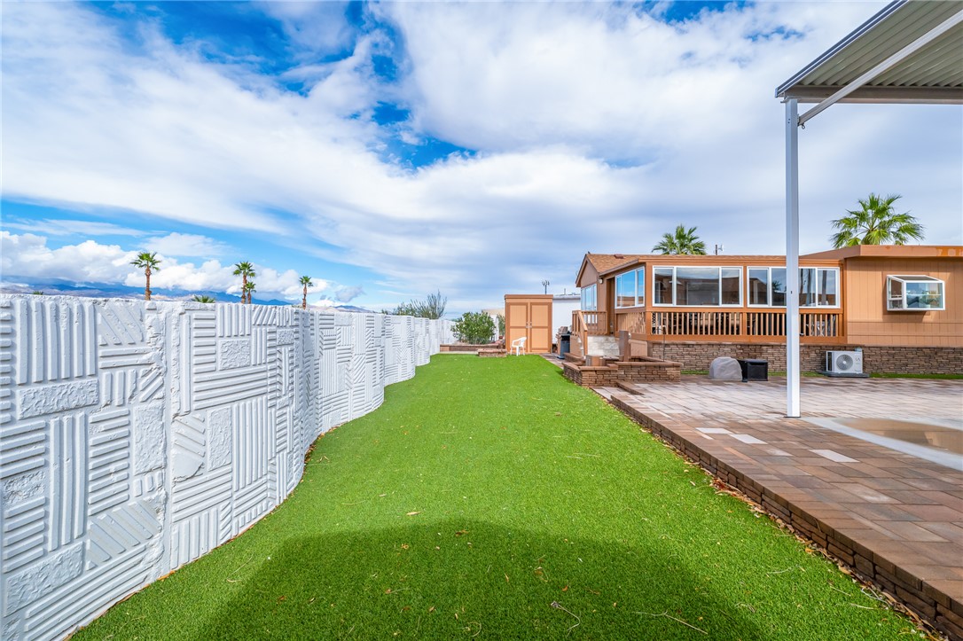 2000 Ramar Road, Unit 126 Bullhead City, AZ 86442 - Photo 31 of 65 Fenced backyard with a patio, an outbuilding, and a sunroom