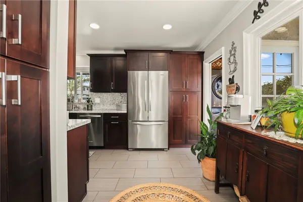 a kitchen with stainless steel appliances granite countertop a refrigerator and a stove top oven
