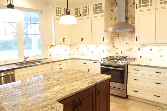 a kitchen with granite countertop a sink and a stove