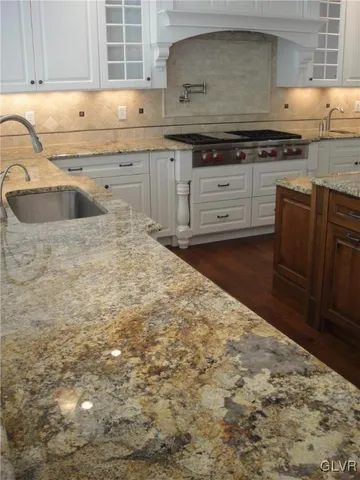 a kitchen with granite countertop a sink and a stove