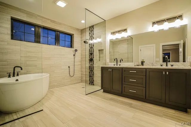 a spacious bathroom with a tub sink mirror and shower