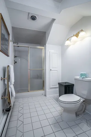 a bathroom with a sink a toilet a mirror and shower