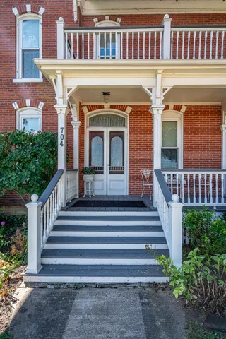 a balcony with wooden floor table and chairs