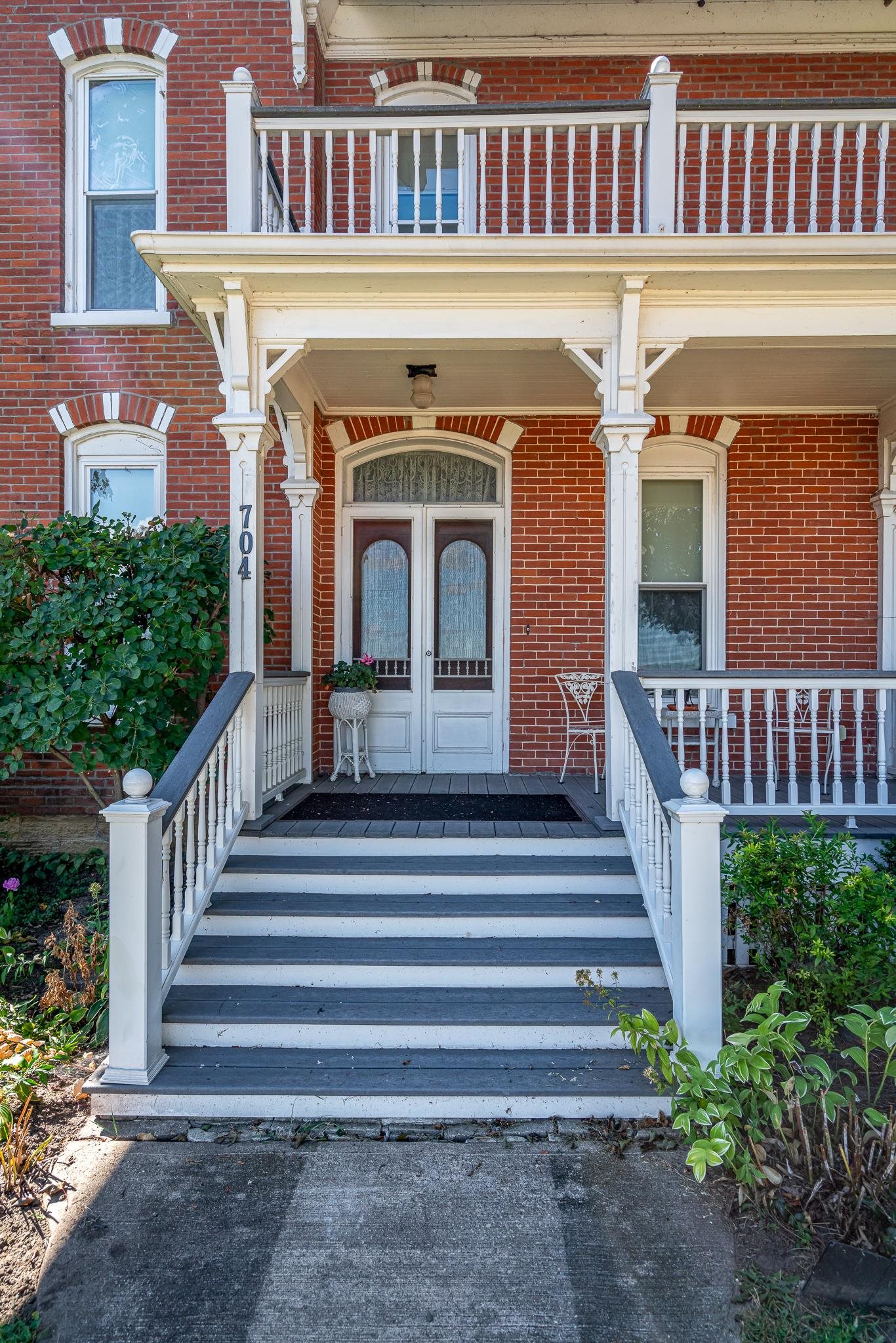 704 River Street Sabula, IA 52070 - Photo 3 of 33 a view of a brick house with plants and wooden fence