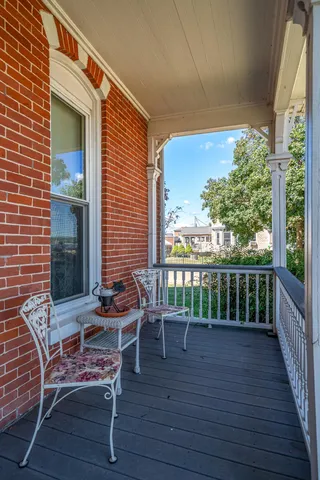 a view of a house with brick walls and a yard with plants