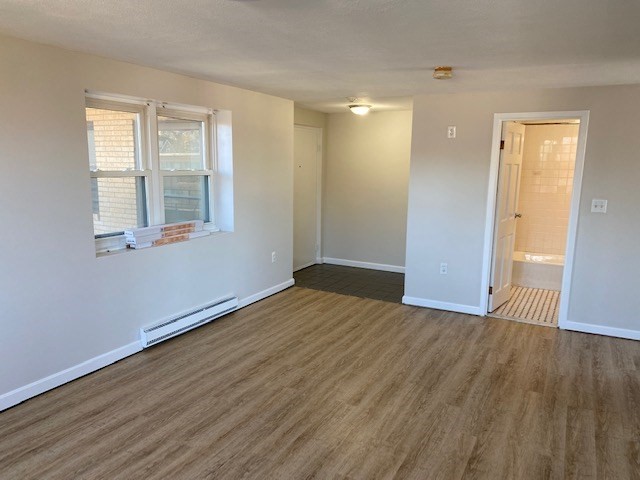 340 Main Street, Unit 501 Melrose, MA 02176 - Photo 3 of 11 a view of an empty room with wooden floor and a window