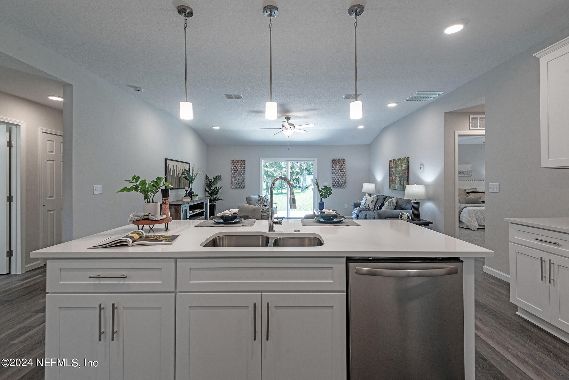 11814 Dunn Creek Road Jacksonville, FL 32218 - Photo 10 of 50 a kitchen with a sink dishwasher and white cabinets with wooden floor