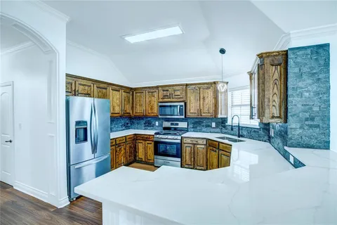 a kitchen with a sink a refrigerator and wooden cabinets
