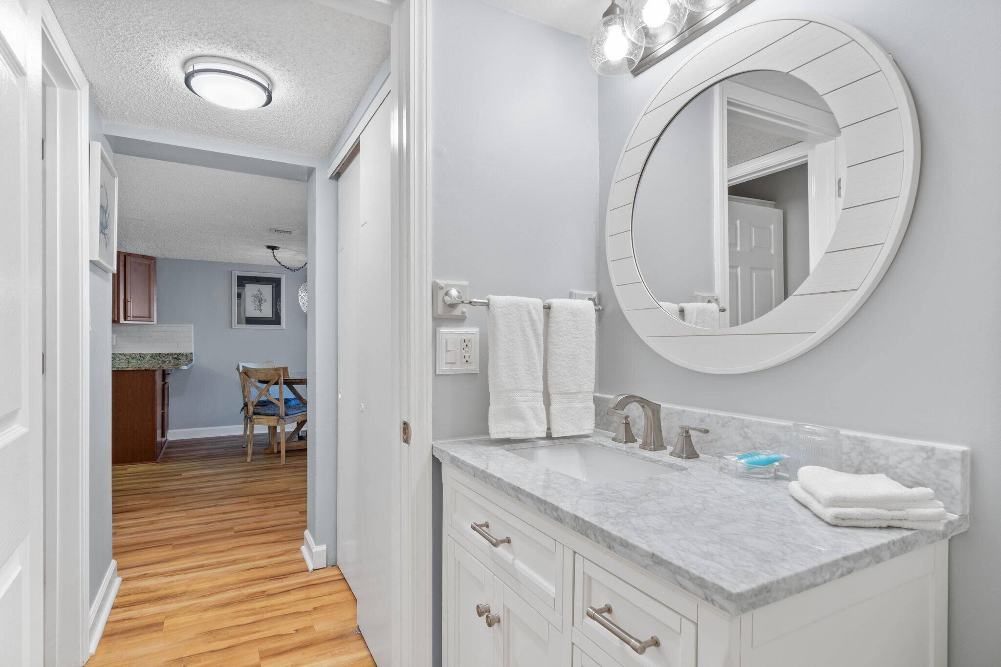 23223 Front Beach Road, Unit 308 Panama City Beach, FL 32413 - Photo 16 of 18 a bathroom with a granite countertop sink a mirror and vanity