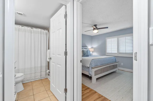 a bathroom with a white tub shower vanity and a toilet