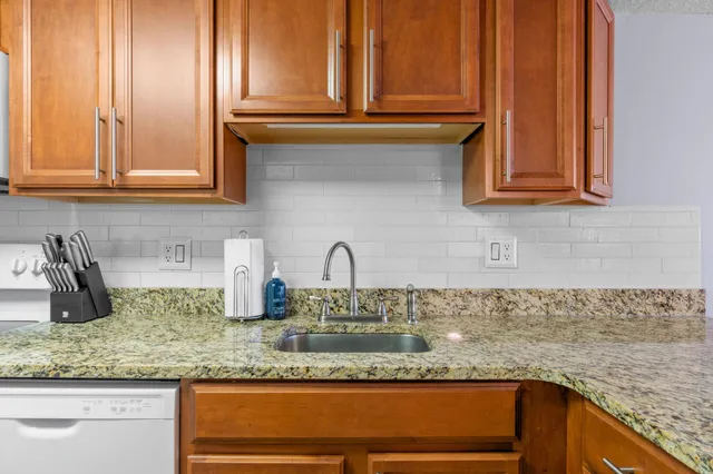 a kitchen with granite countertop stainless steel appliances sink and cabinets