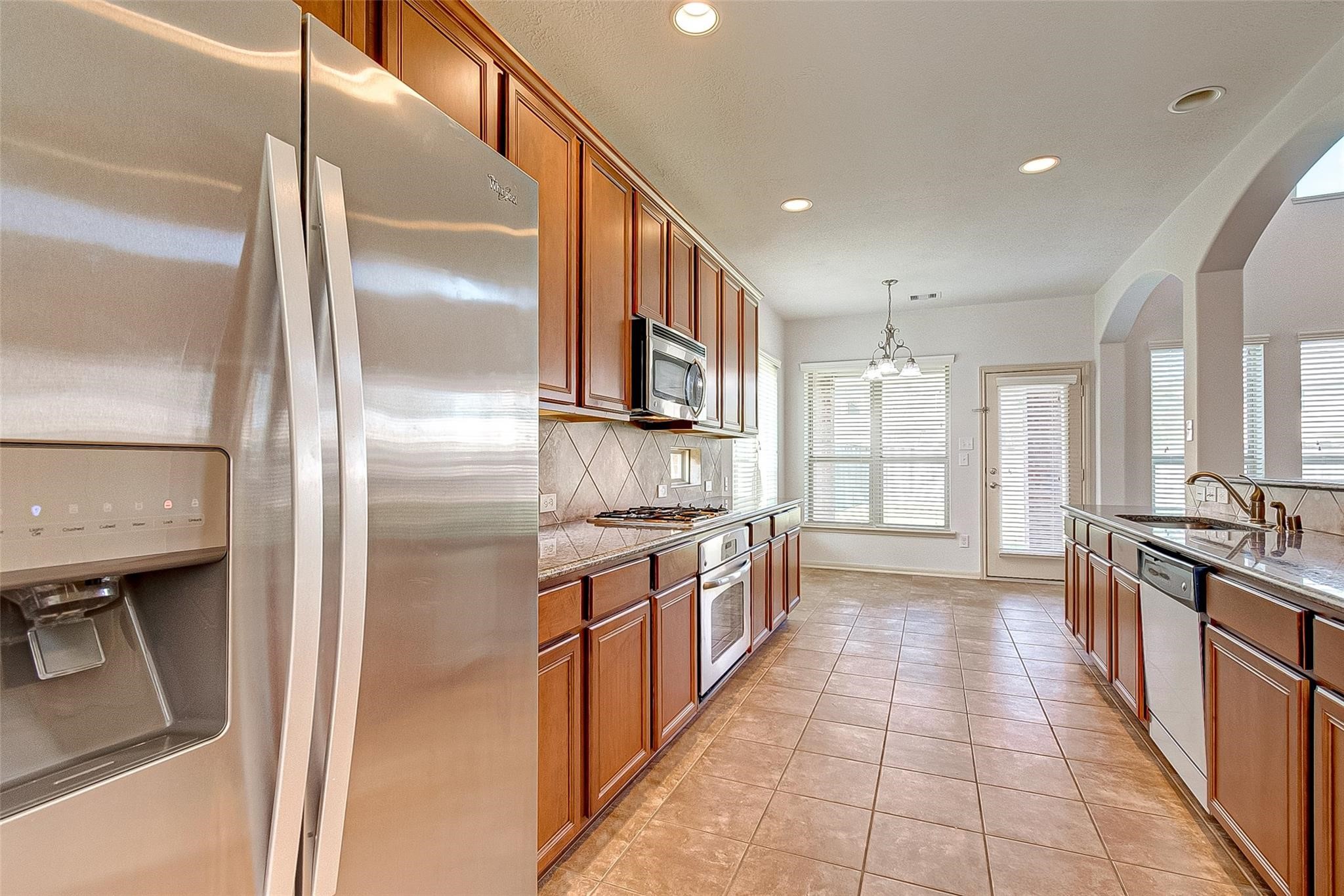 79 West Lasting Spring Circle Spring, TX 77389 - Photo 24 of 48 a large kitchen with stainless steel appliances granite countertop a refrigerator and a sink