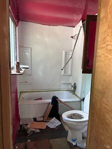 a white toilet sitting next to a bathroom sink and vanity