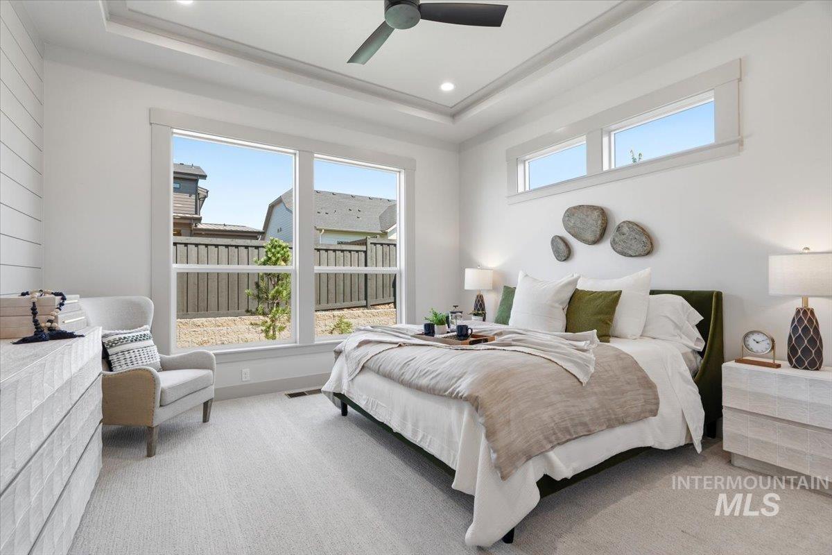 6762 South Messner Way Meridian, ID 83642 - Photo 14 of 35 Bright bedroom featuring a tray ceiling with recessed lighting and a ceiling fan