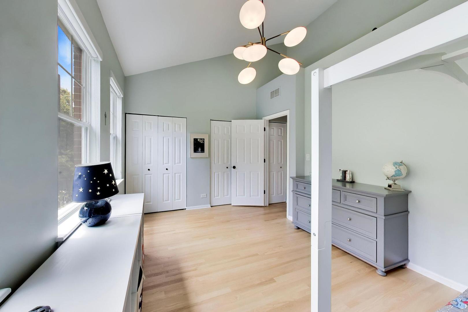 232 West Scott Street Chicago, IL 60610 - Photo 21 of 39 a spacious bedroom with a bed and a chandelier