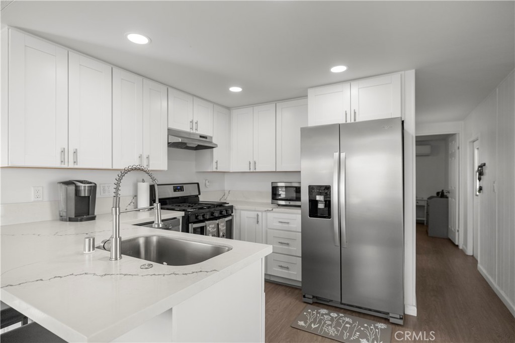 27150 Shadel Road, Unit 122 Menifee, CA 92586 - Photo 7 of 26 a kitchen with stainless steel appliances granite countertop a refrigerator a sink a stove a microwave and a refrigerator