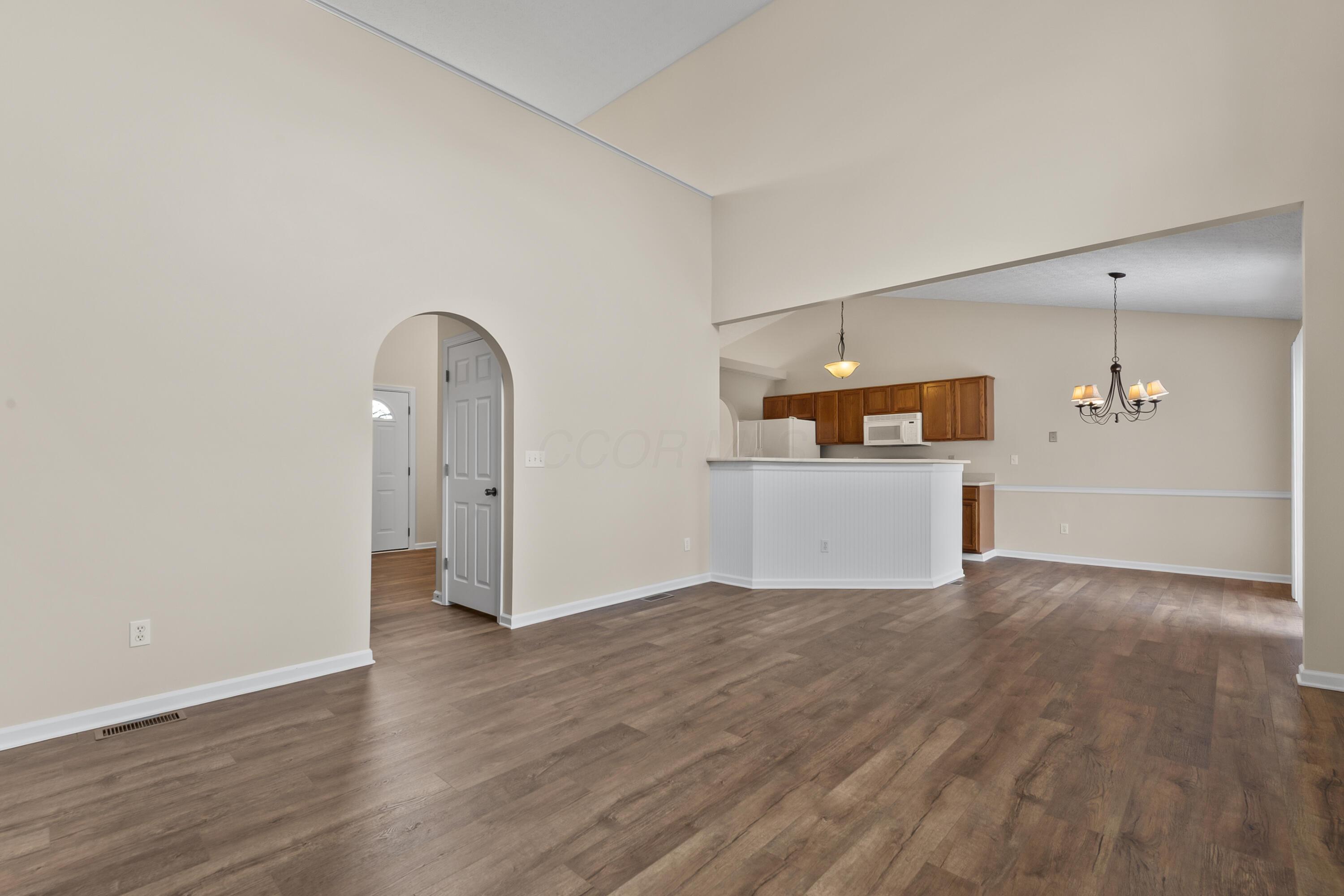 30 Tabilore Loop Delaware, OH 43015 - Photo 11 of 55 • New luxury vinyl plank flooring ~ 2025 • Tan painted walls • Two-story ceiling • Rectangular & half round window • Lighted ceiling fan