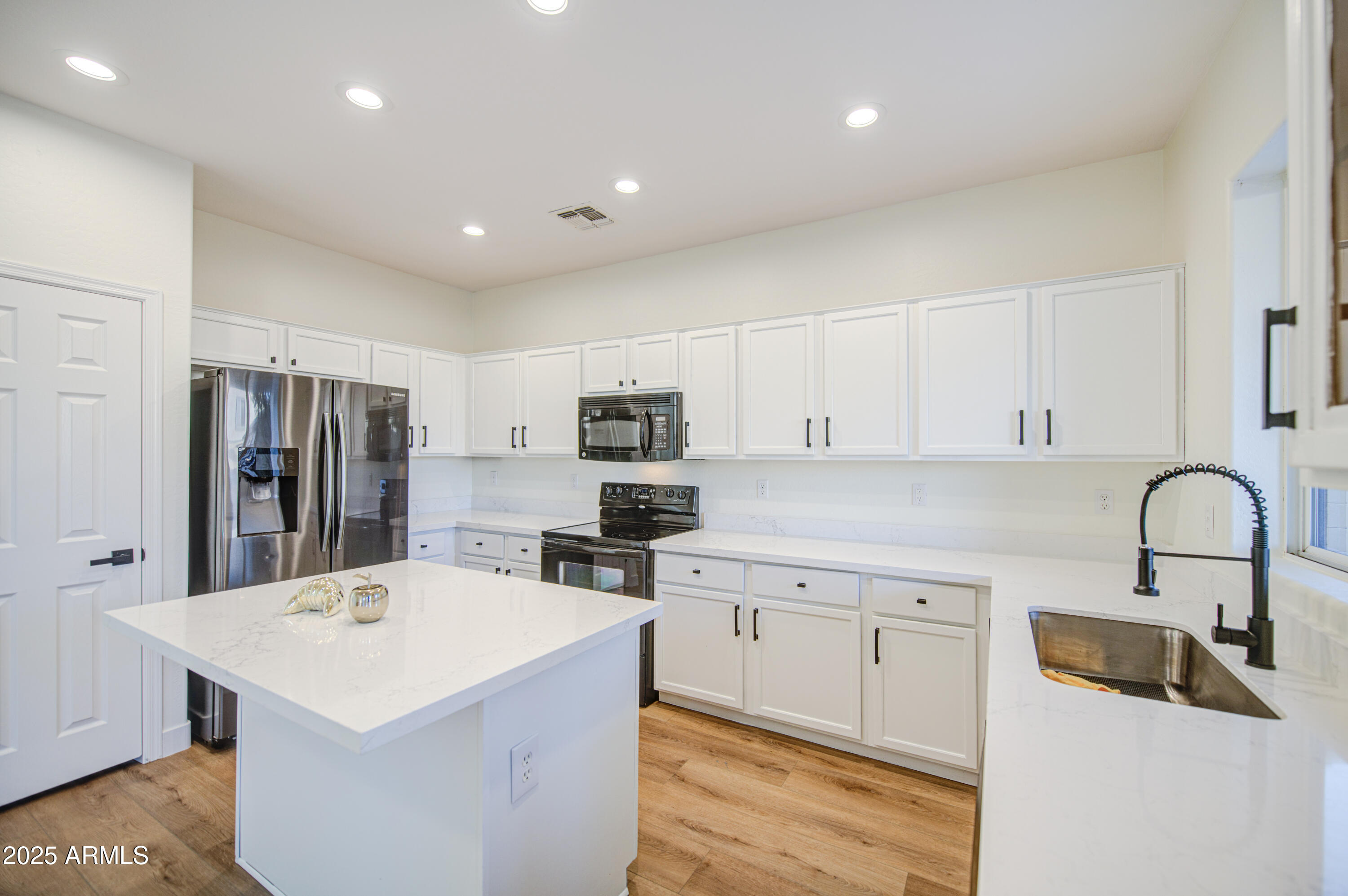 22022 West Moonlight Path Buckeye, AZ 85326 - Photo 11 of 49 a kitchen with a sink a counter top space cabinets and stainless steel appliances