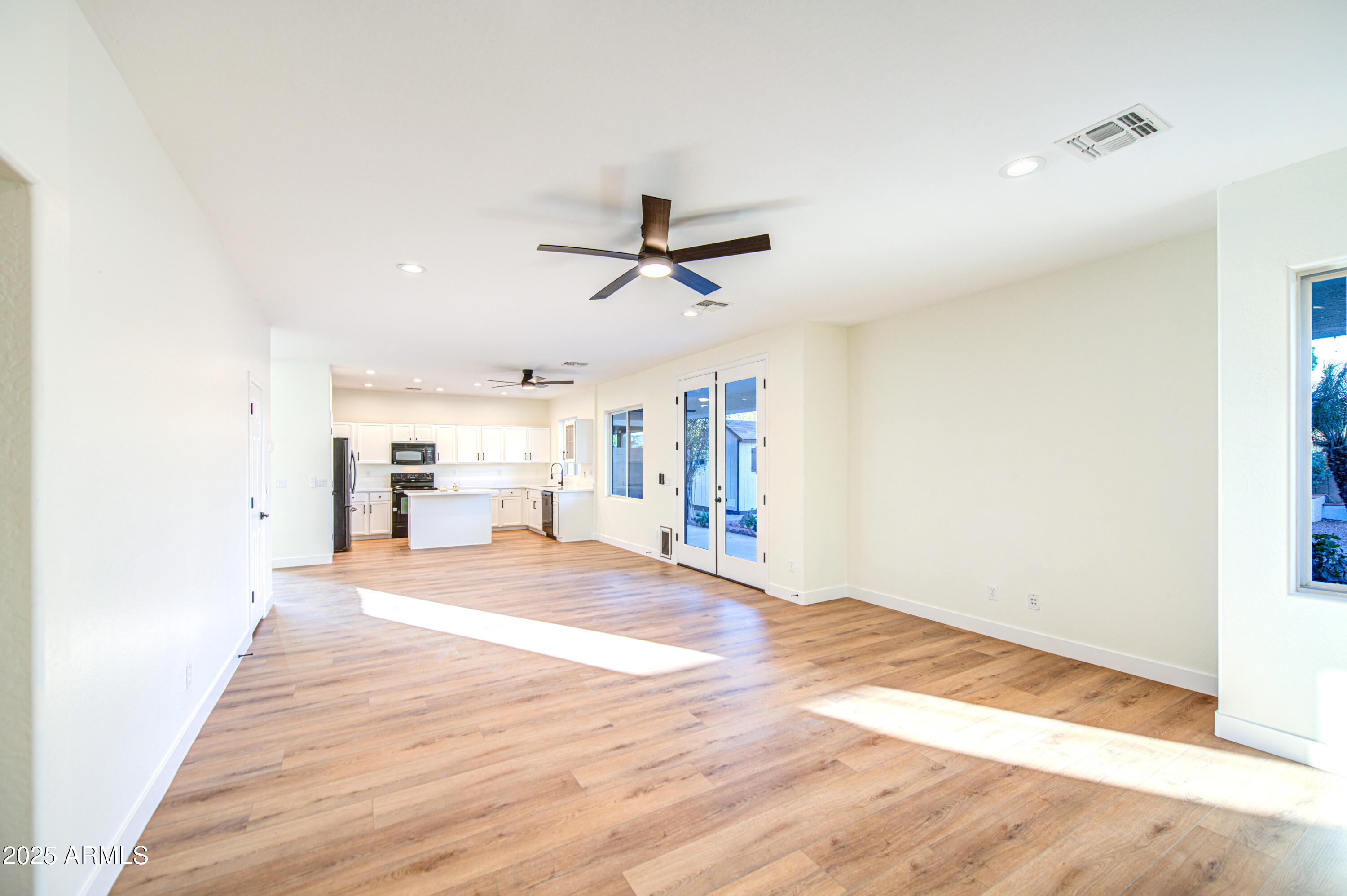 22022 West Moonlight Path Buckeye, AZ 85326 - Photo 12 of 49 a view of a livingroom with a hardwood floor and a ceiling fan
