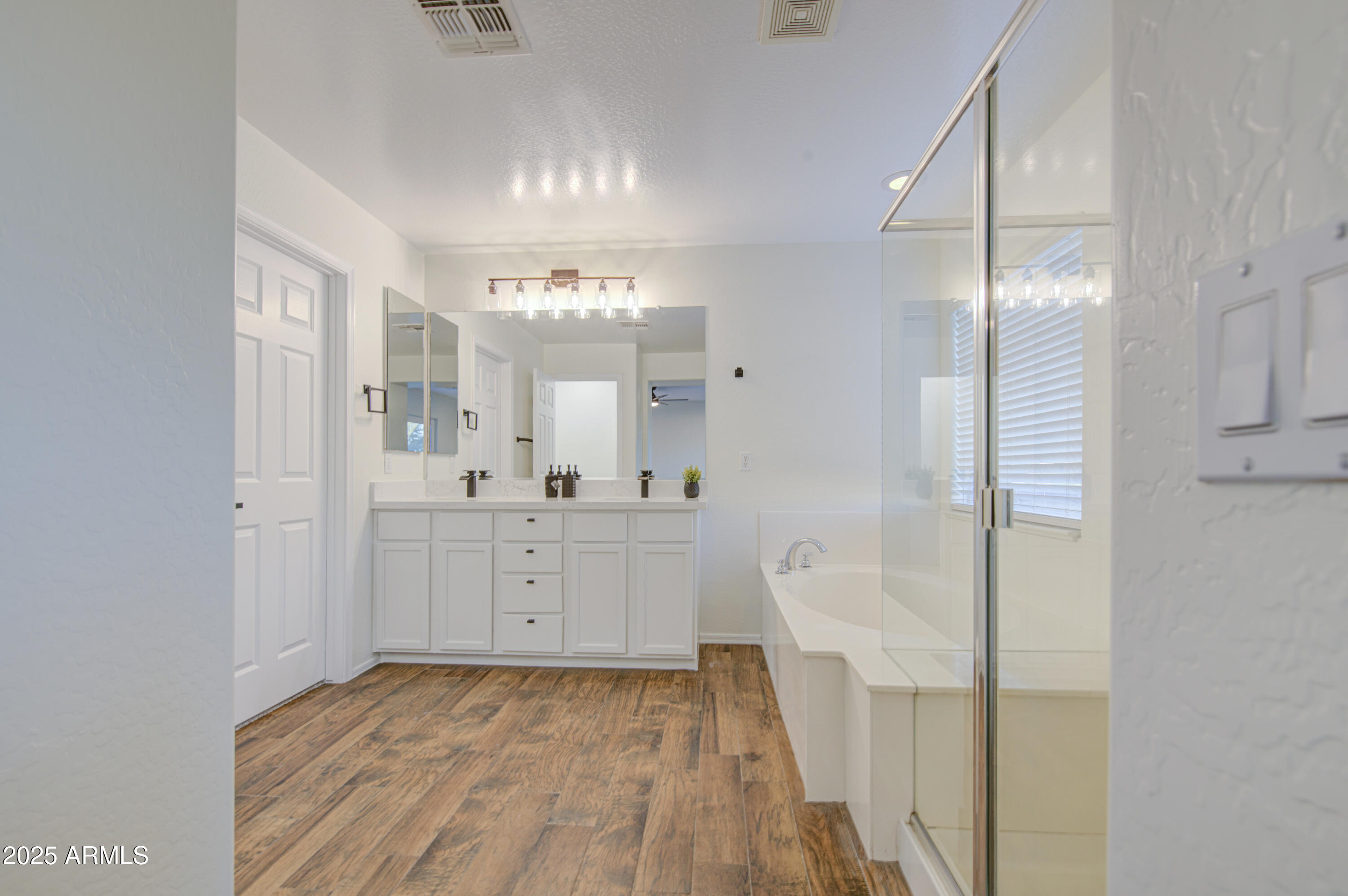22022 West Moonlight Path Buckeye, AZ 85326 - Photo 35 of 49 a bathroom with a sink a mirror and a shower