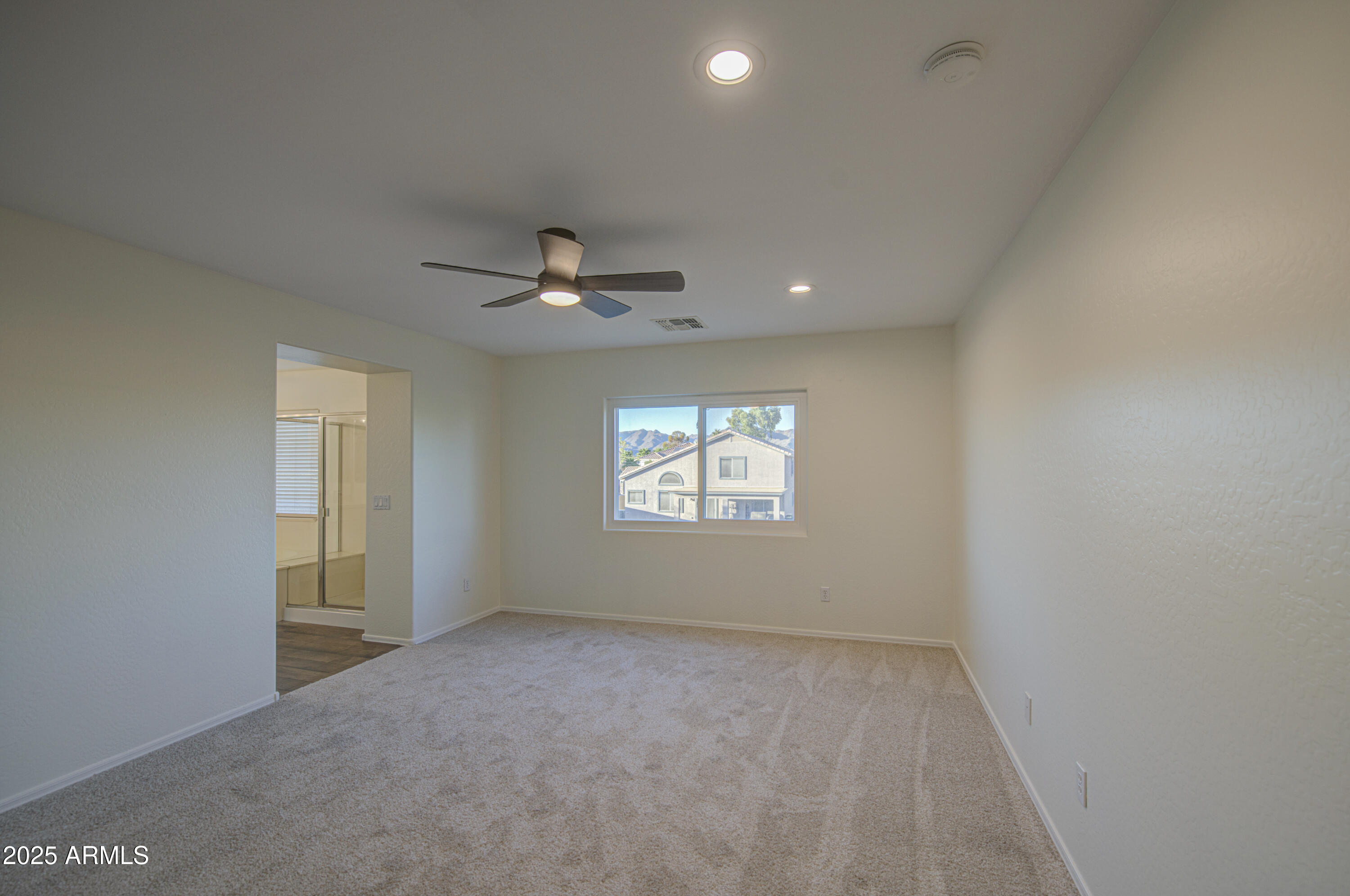 22022 West Moonlight Path Buckeye, AZ 85326 - Photo 37 of 49 en empty room with windows and ceiling fan