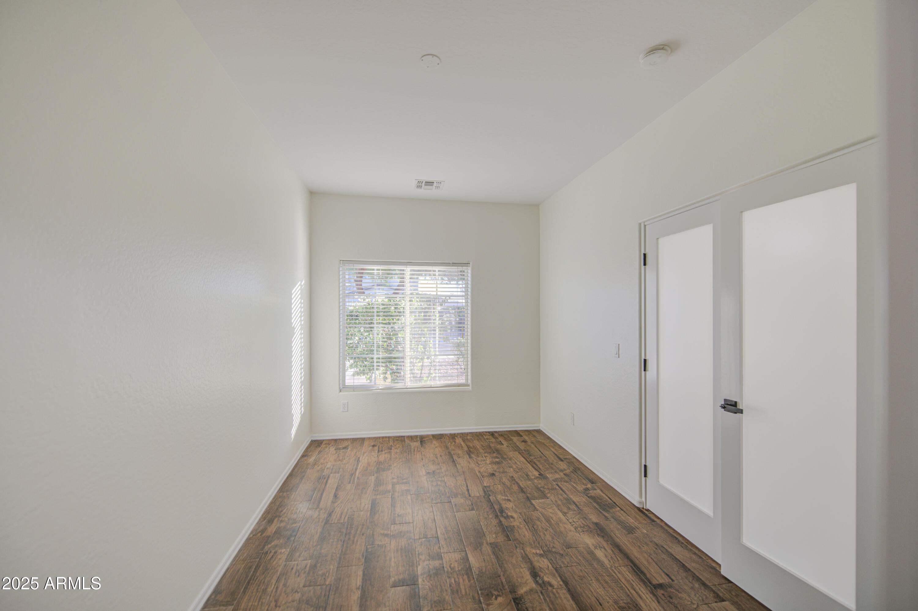 22022 West Moonlight Path Buckeye, AZ 85326 - Photo 7 of 49 an empty room with wooden floor and windows