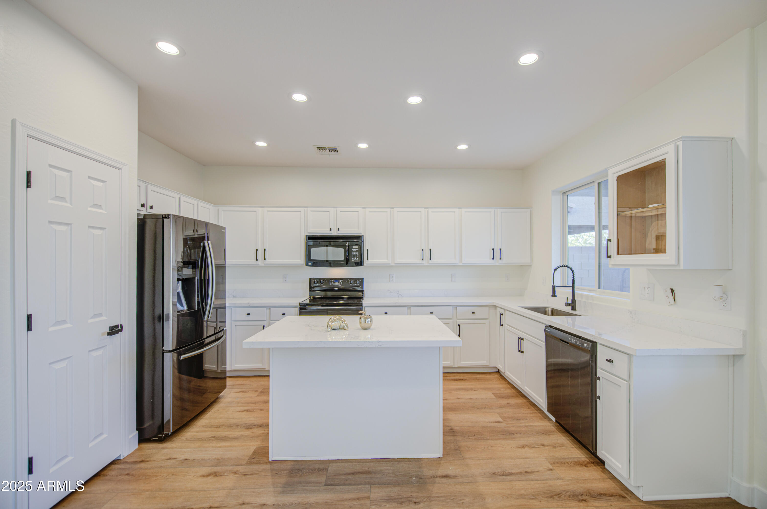 22022 West Moonlight Path Buckeye, AZ 85326 - Photo 10 of 49 a large kitchen with stainless steel appliances lots of counter space and wooden floor