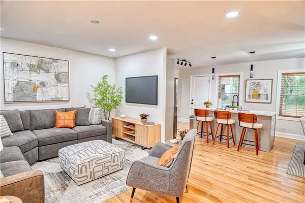 a living room with furniture flat screen tv and wooden floor
