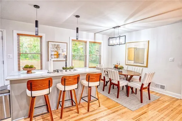 a view of a dining room and livingroom with furniture wooden floor a chandelier