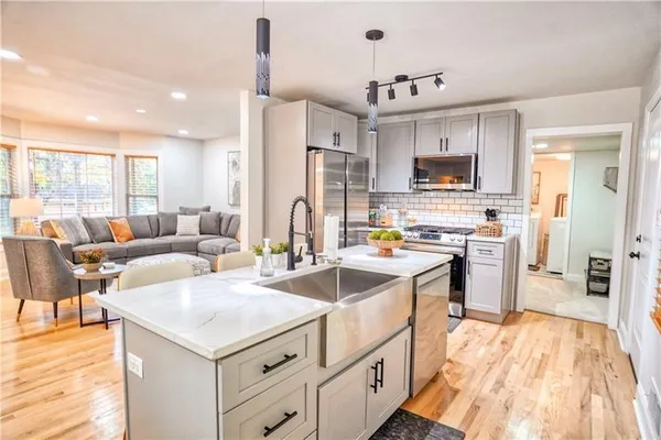 a kitchen with stainless steel appliances granite countertop a sink and a refrigerator