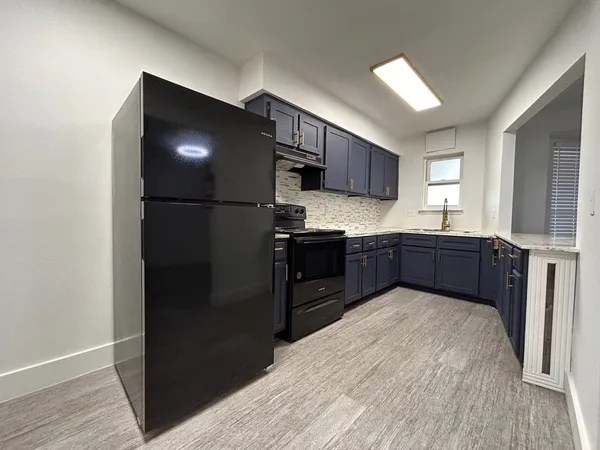 a kitchen with stainless steel appliances granite countertop a refrigerator and a sink