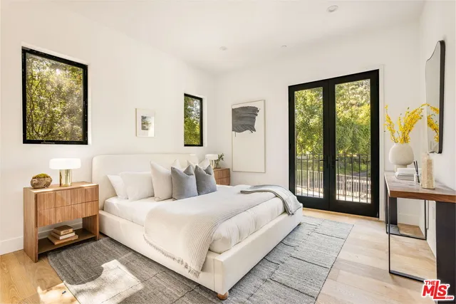 a bedroom with a bed and a dresser next to a window