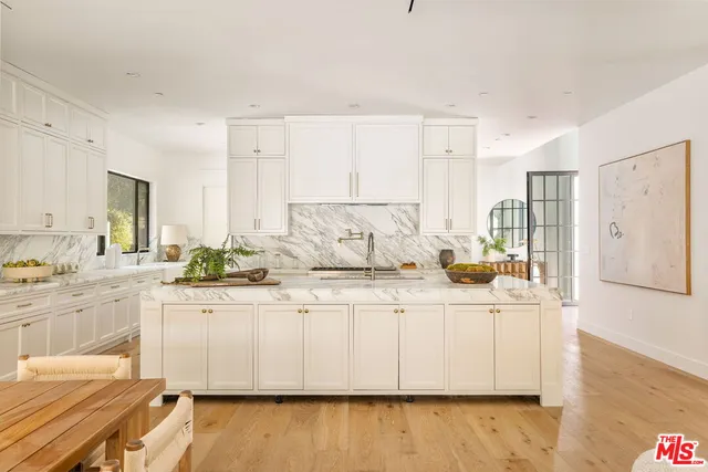 a large white kitchen with stainless steel appliances