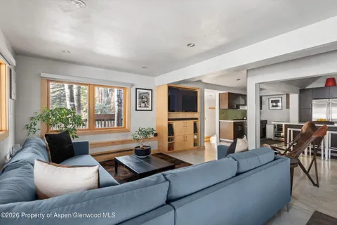 a living room with furniture flat screen tv and large windows