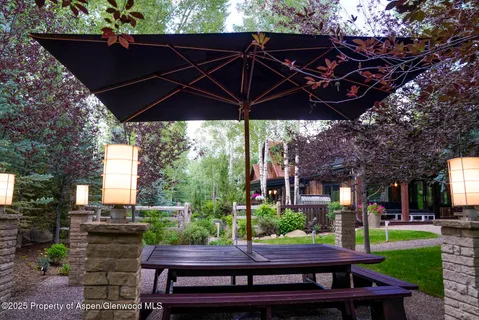 a roof deck with a table and chairs under an umbrella