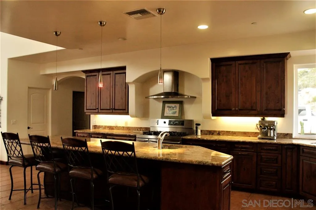 17315 Lyons Creek Road Jamul, CA 91935 - Photo 5 of 25 a kitchen with a sink cabinets and wooden floor