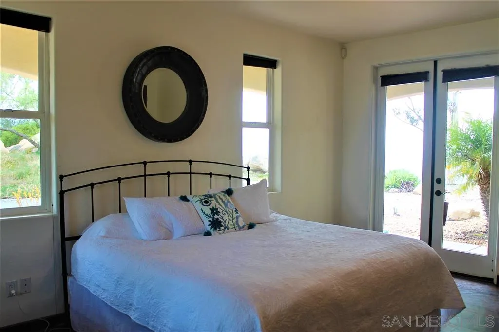 17315 Lyons Creek Road Jamul, CA 91935 - Photo 6 of 25 a bedroom with a large bed and a large window