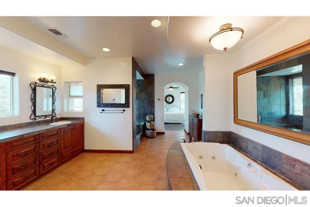 17315 Lyons Creek Road Jamul, CA 91935 - Photo 7 of 25 a bathroom with a tub sink and mirror