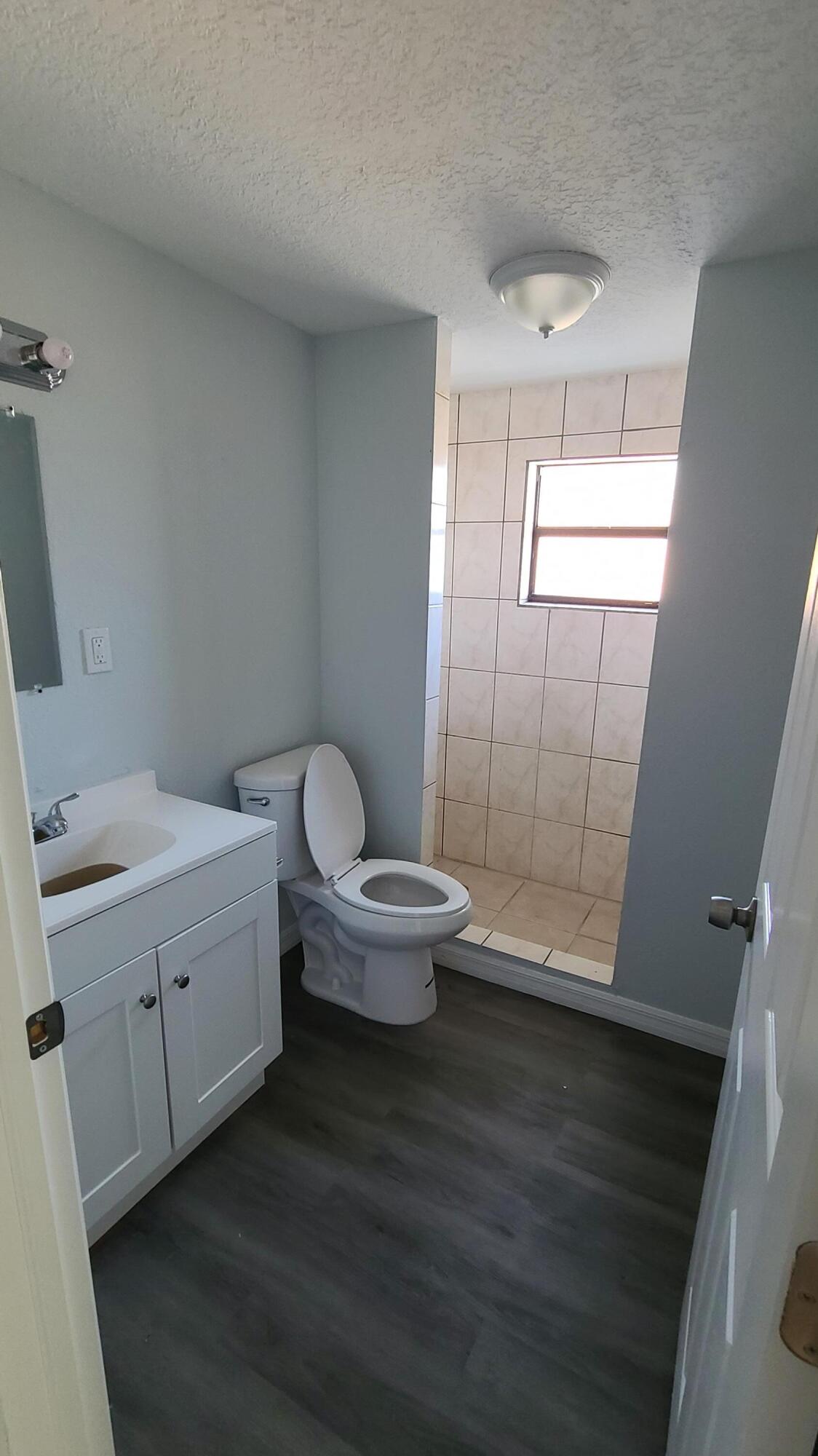 921 14th Street West Palm Beach, FL 33401 - Photo 16 of 36 a bathroom with a toilet a sink and shower