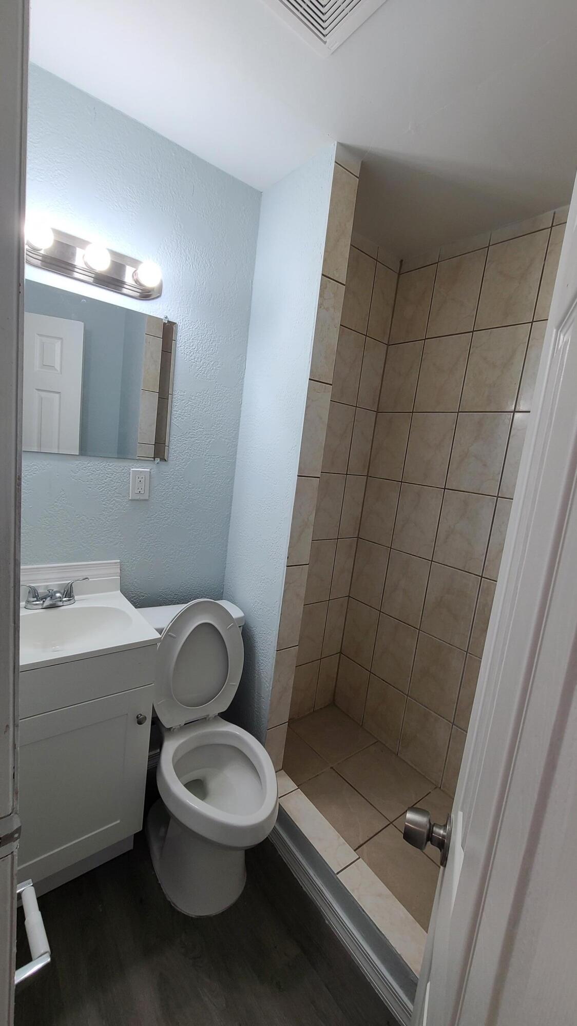 921 14th Street West Palm Beach, FL 33401 - Photo 20 of 36 a bathroom with a toilet a sink and mirror