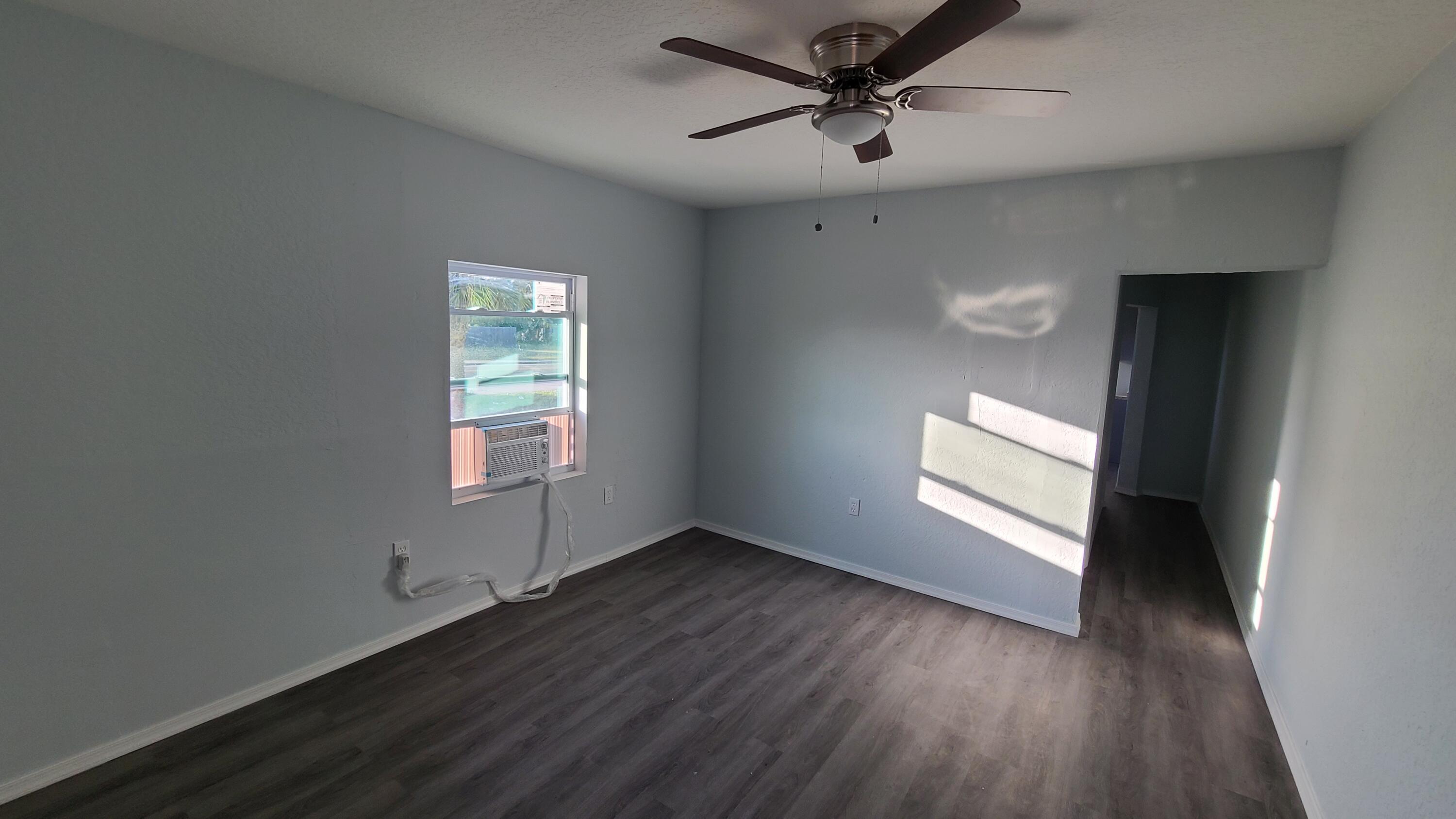921 14th Street West Palm Beach, FL 33401 - Photo 21 of 36 an empty room with wooden floor ceiling fan and windows